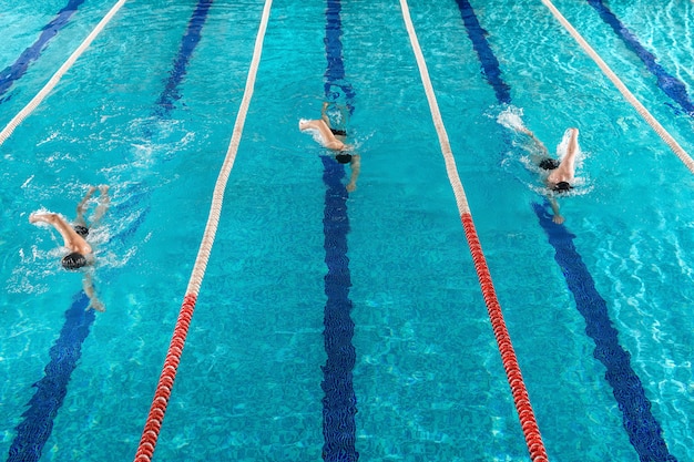 Three male swimmers racing against each other