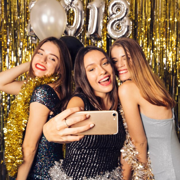 Three party girls taking selfie on new year celebration