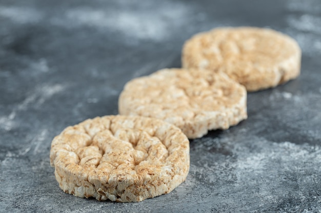 Three puffed rice cakes on marble surface