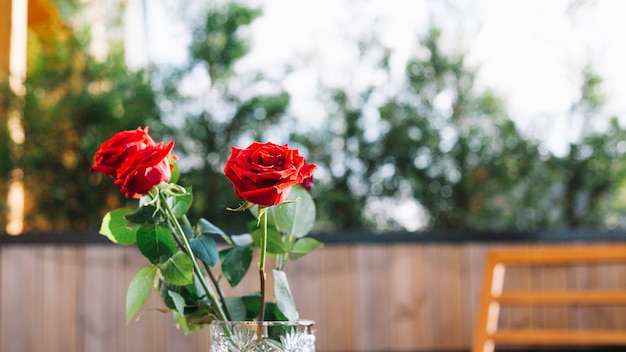 Three red roses in the glass vase