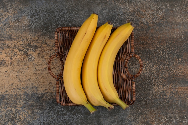 Three ripe bananas in wooden basket