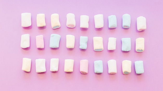 Free photo three rows of marshmallow on pink background