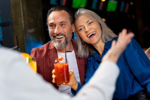 Three senior friends drinking and laughing at a restaurant