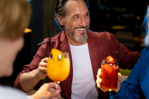 Three senior friends drinking and talking at a restaurant