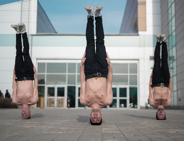 Free Photo three shirtless hip hop standing on their heads