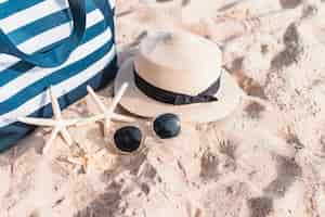 Free photo three starfishes with bag on sand