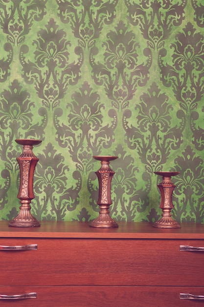 Free photo three vintage chandeliers on green rococo style pattern background. rich interior. vintage toning