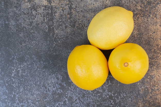 Free photo three whole fresh lemons on marble space