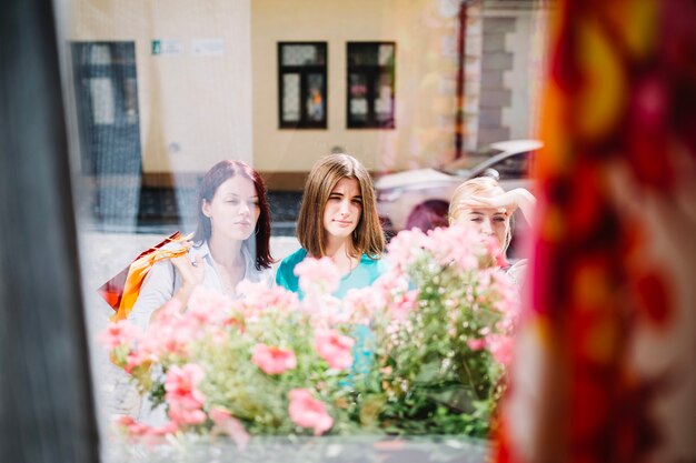 Free photo three women looking through shop-window