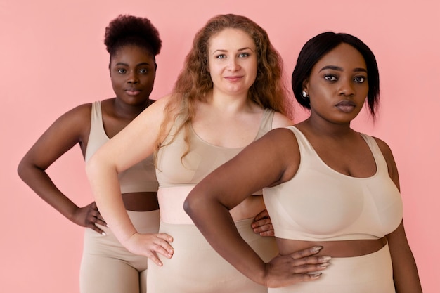 Free photo three women posing while wearing a body shaper