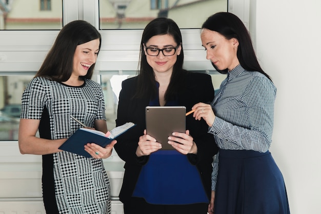 Free photo three women with tablet and documents