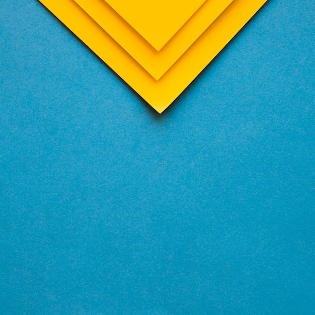 Three yellow cardboard papers at the top of blue backdrop