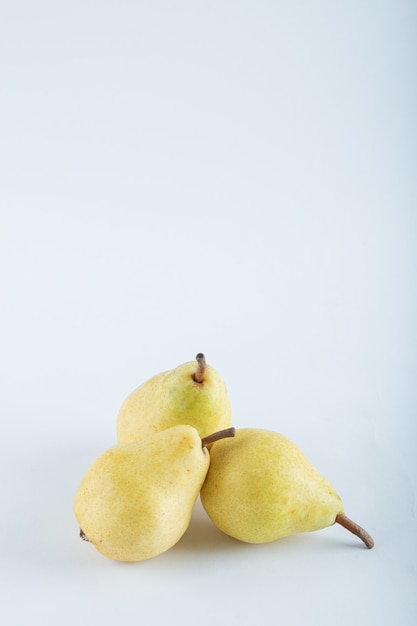 Free Photo three yellow pears on white.