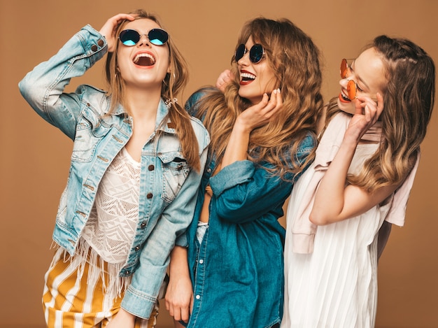 Free photo three young beautiful smiling girls in trendy summer casual jeans clothes. sexy carefree women posing. positive models in sunglasses