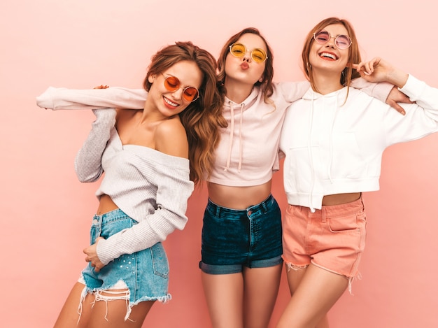 Three young beautiful smiling girls in trendy summer clothes. Sexy carefree women posing. Positive models having fun