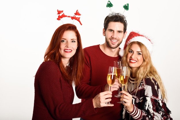 Free Photo three young people toasting with champagne on white background