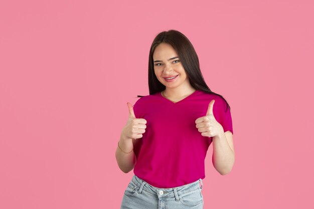 Thumbs up. Monochrome portrait of young caucasian brunette woman isolated on pink studio wall.