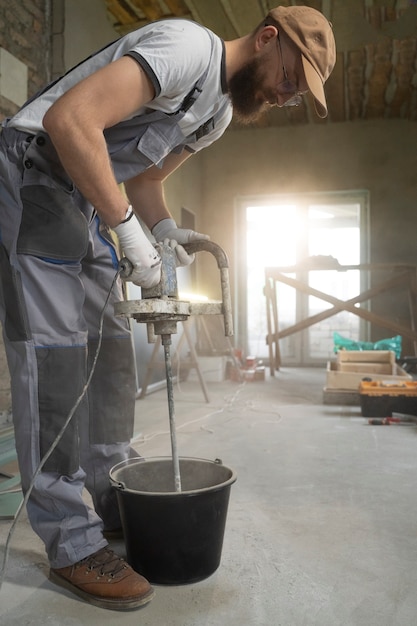 Free photo tiler working on renovation of apartment