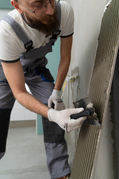 Free photo tiler working on renovation of apartment