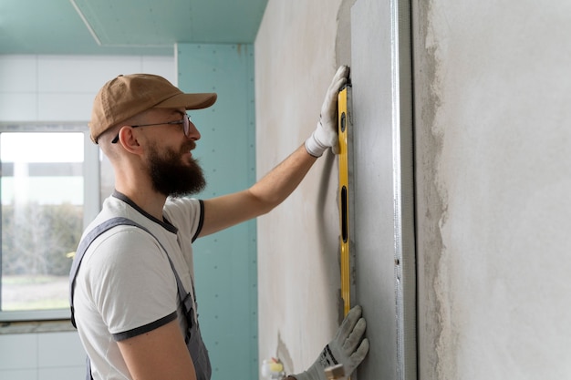 Free photo tiler working on renovation of apartment