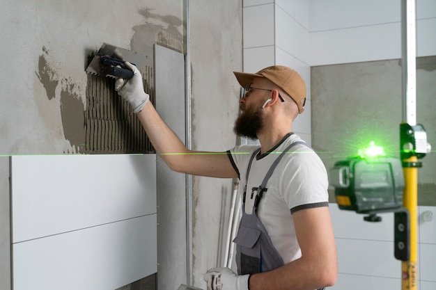 Free photo tiler working on renovation of apartment