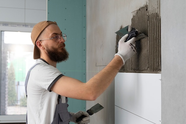 Free photo tiler working on renovation of apartment