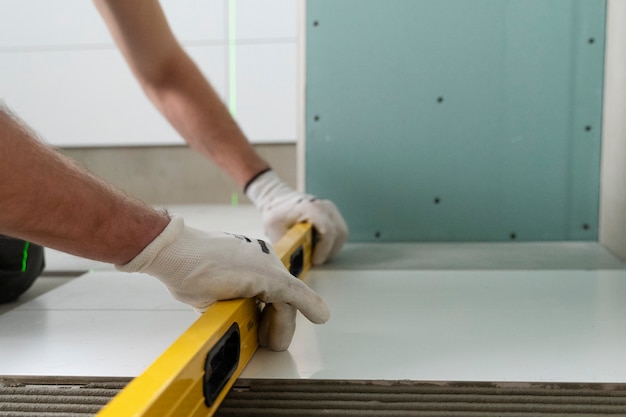 Free photo tiler working on renovation of apartment