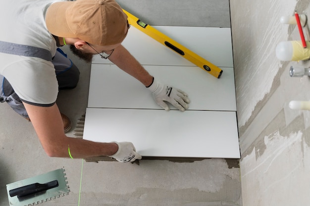 Free photo tiler working on renovation of apartment