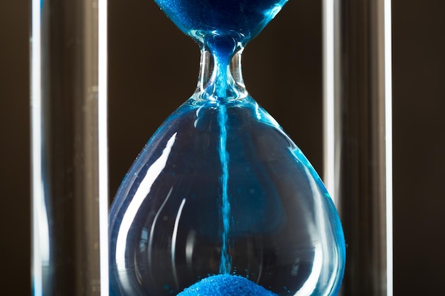 Time is passing. Blue hourglass close up