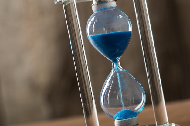 Time is passing. Blue hourglass close up