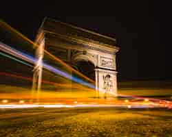 Free photo timelapse shot of light trails around arc de triomphe in paris, france.