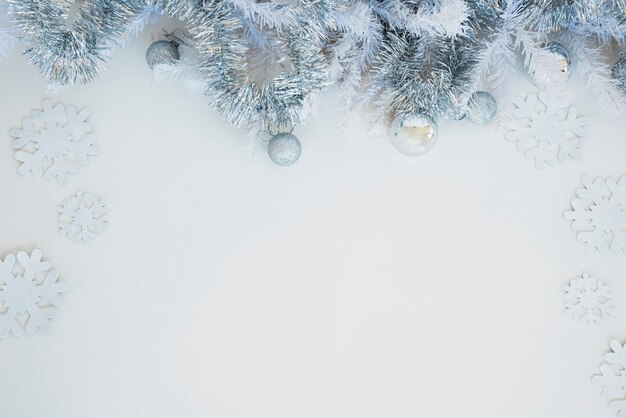 Tinsel with shiny baubles on table 