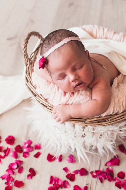 Tiny newborn in headband sleeping