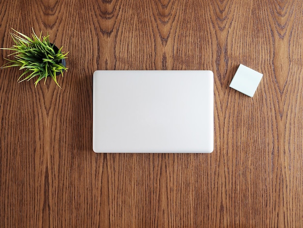 Free Photo tip view of businessman desk with a laptop and a pot of grass. flatlay  image