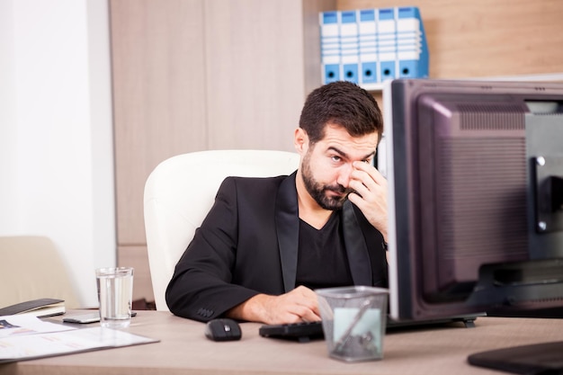 Free photo tired businessman working in his office. businessperson in professional environment