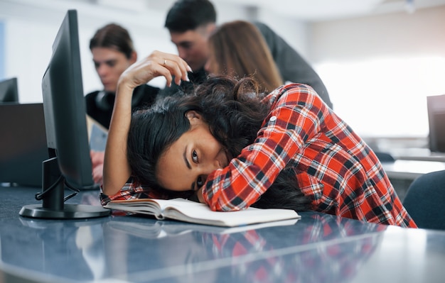 Tired a little. Group of young people in casual clothes working in the modern office