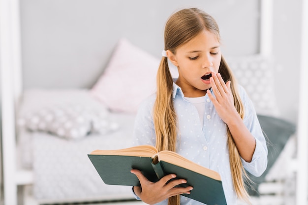 Tired lovely girl reading a book