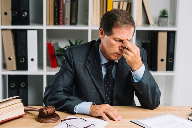 Tired mature lawyer sitting in the courtroom