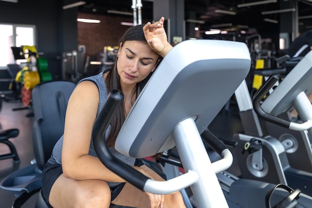 Free photo tired woman in the gym tired woman after training in the gym