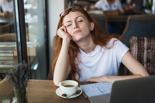 Tired woman sitting at table