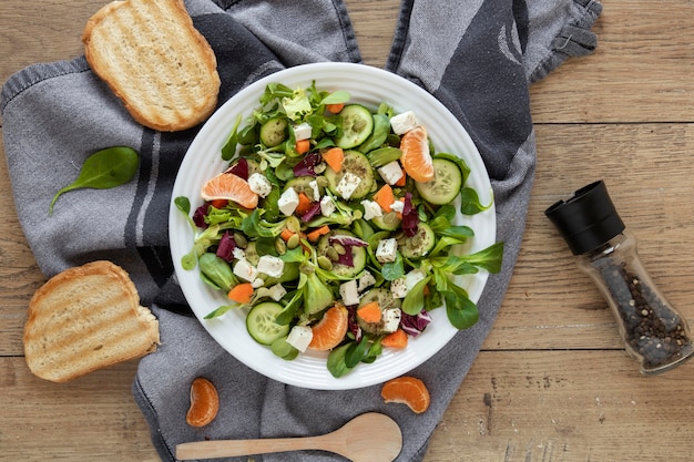 Free photo toast bread beside plate with salad on table