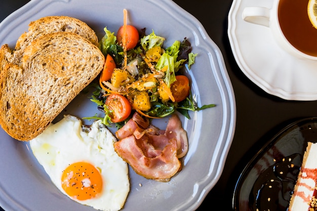 Free Photo toast; salad; fried eggs; bacon on ray plate