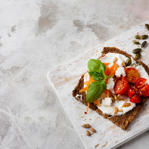 Toast slice with cherry tomatoes on marble high view