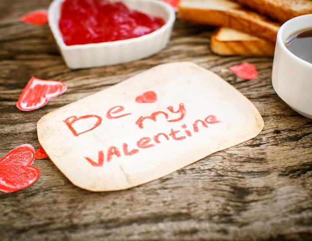 Free photo toast with strawberry jam be my valentine white message card with coffee valentine's day