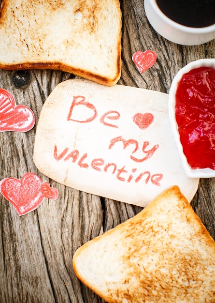 Toast with strawberry jam Be My Valentine white message card with hand made hearts Valentine's Day