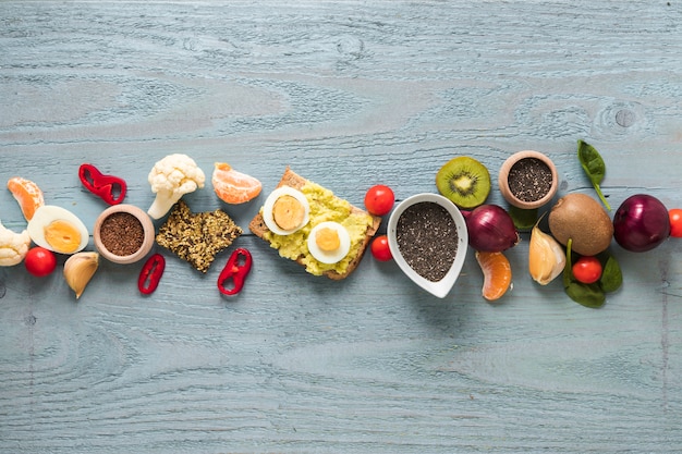 Free Photo toasted bread; fresh fruits and ingredients arranged in a row on wooden table