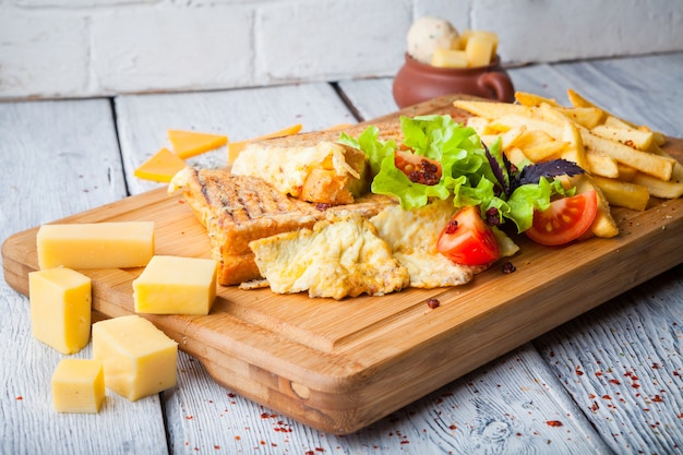 toasts with cheese and tomatoes and french fries in plate