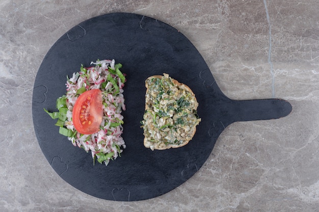 Free Photo toasts with tasty salad on dark board.