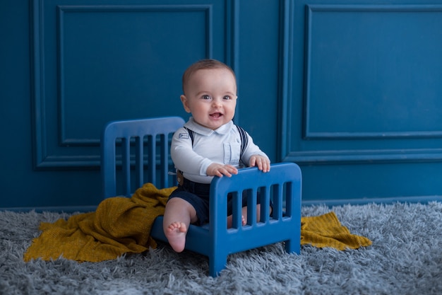 A toddler with elegant outfist inside decorative bed in the room.