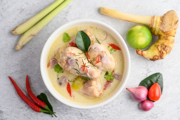 Tom Kha Kai in a bowl with kaffir lime leaves, lemongrass, red onion, galangal and chilli.